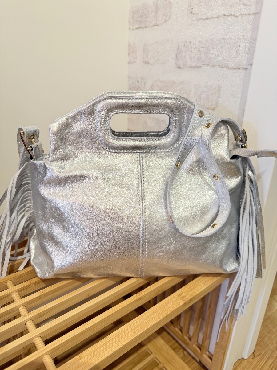 MAG, le sac avec ses franges sur le côté qui donne une touche d’éclat à vos tenues au design élégant et contemporain. Confectionné dans un cuir métallisé souple, il allie style et praticité pour un look tendance au quotidien comme en soirée. On aime sa bandoulière rivets et son porté main élégant.