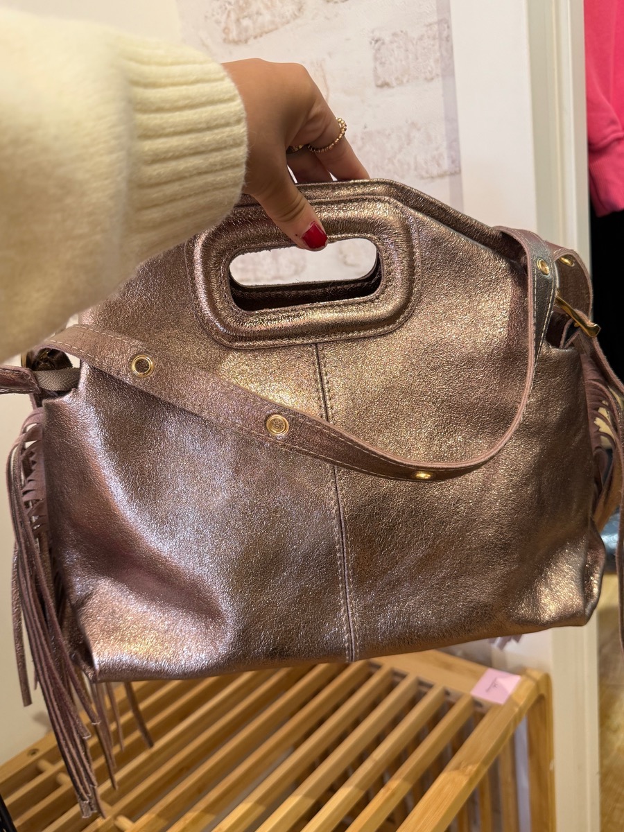 MAG, le sac avec ses franges sur le côté qui donne une touche d’éclat à vos tenues au design élégant et contemporain. Confectionné dans un cuir métallisé souple, il allie style et praticité pour un look tendance au quotidien comme en soirée. On aime sa bandoulière rivets et son porté main élégant.